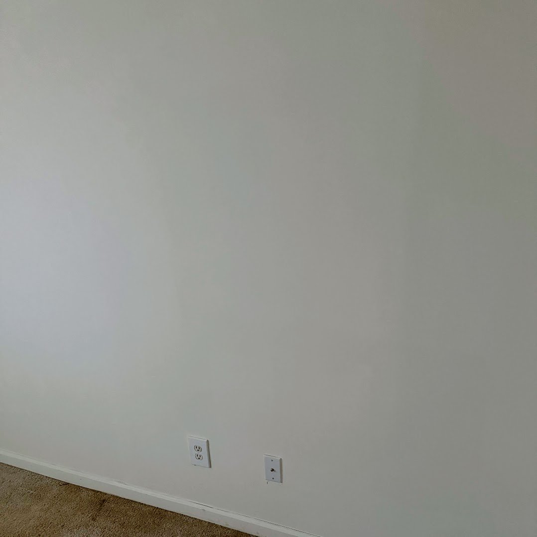 Wall after HVAC post-trade drywall patch, finish-ready