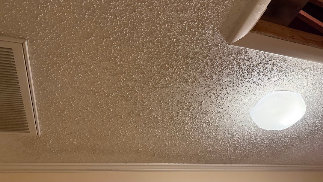 Water damaged ceiling after repair and texture match